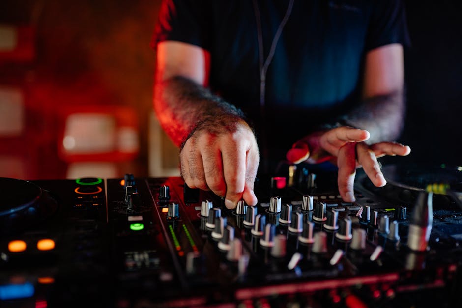 DJ hand cueing the next track on a club mixer