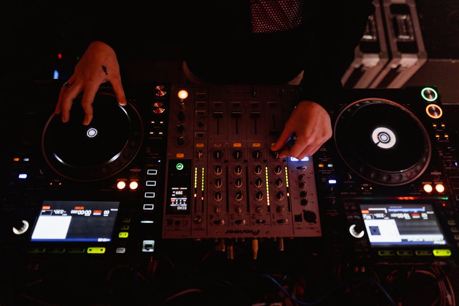 DJ working on music library organization on a laptop with headphones
