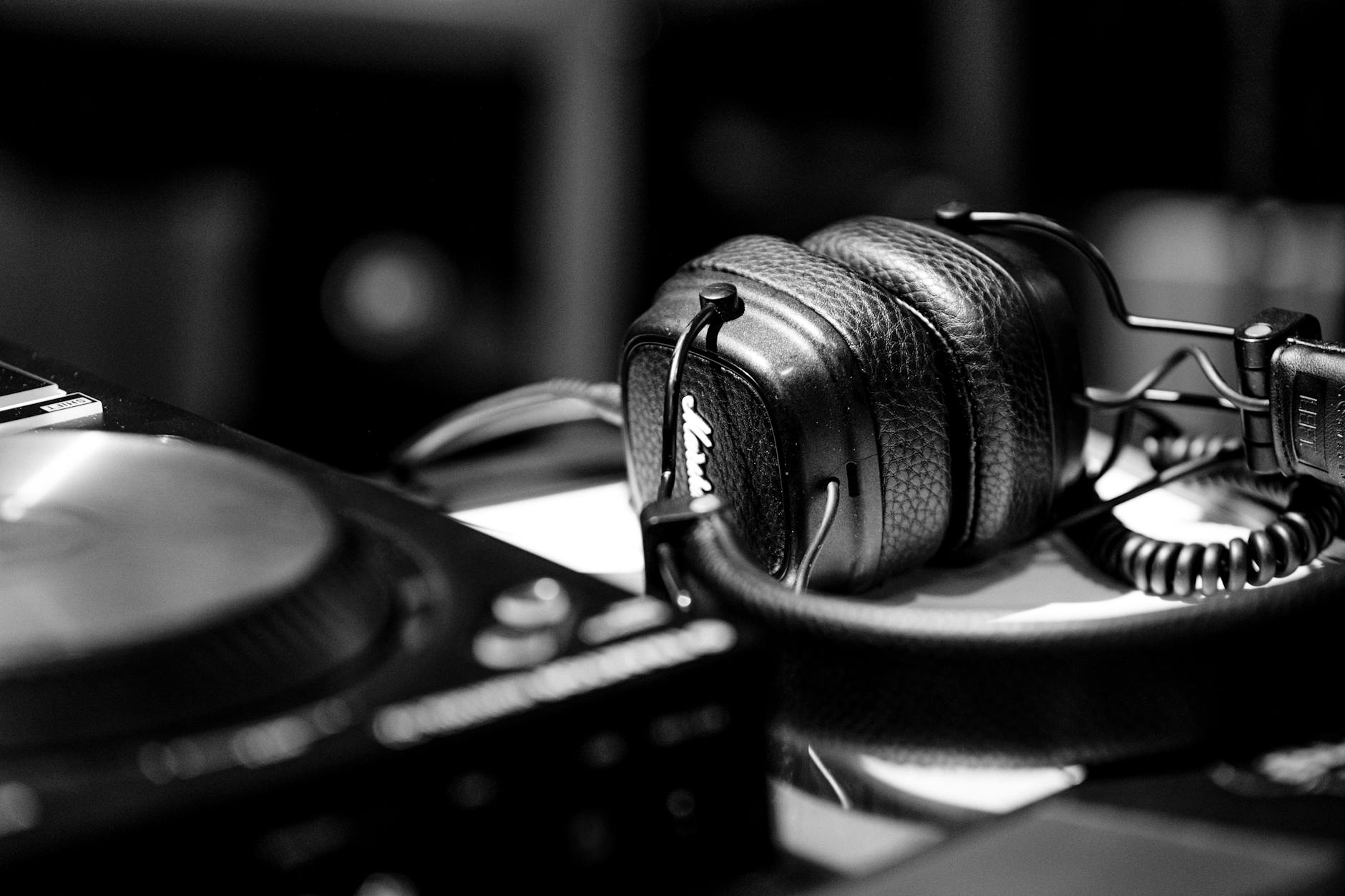 DJ wearing headphones cueing the next track on a controller